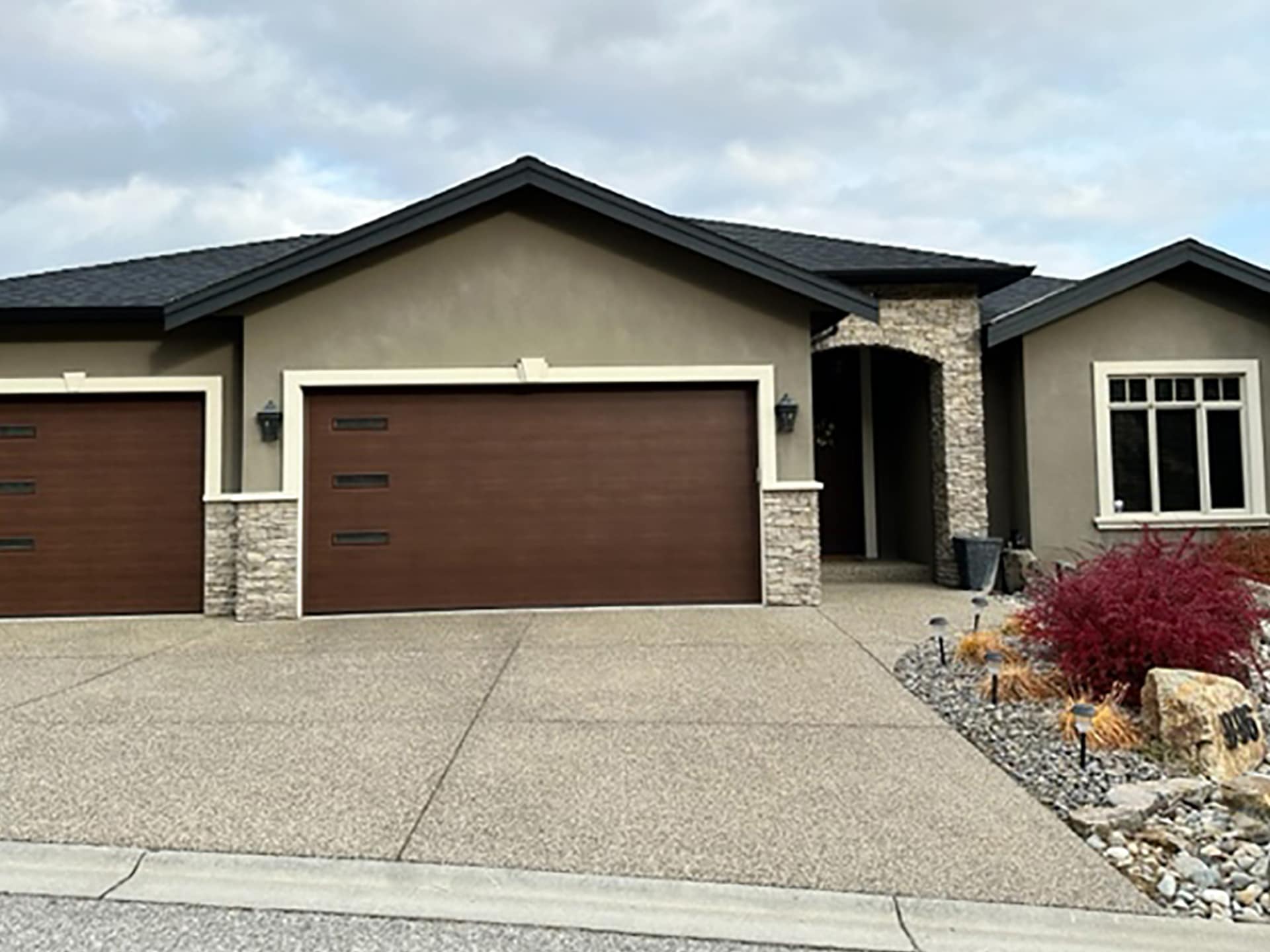 Newly installed residential garage door by Legacy Garage Doors, featuring a modern design with clean lines, set against a bright, contemporary home exterior