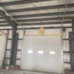 Inside view of a 16x14-foot steel garage door with a high-lift system, showing the backing and support structure