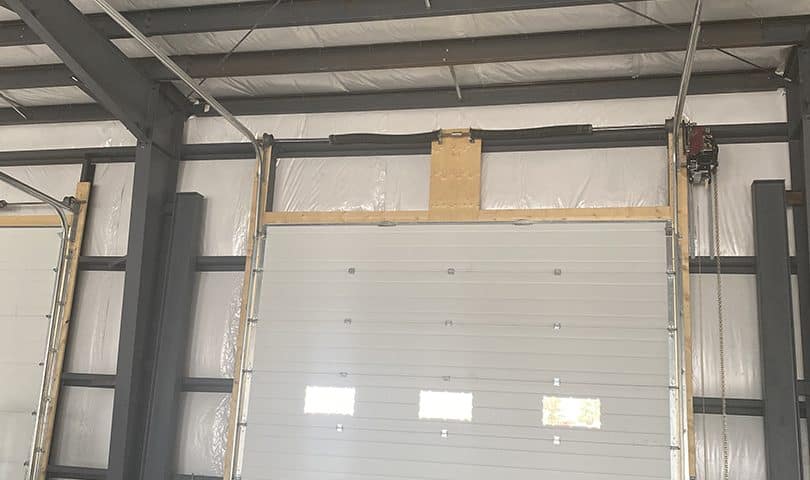 Inside view of a 16x14-foot steel garage door with a high-lift system, showing the backing and support structure