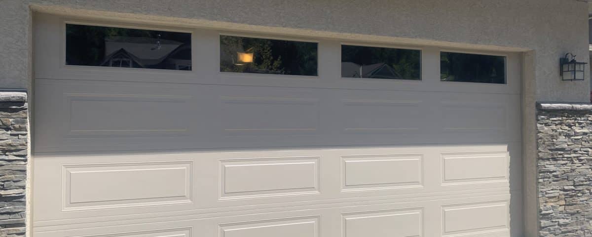 RC16 sandstone garage door with top panel glass by Legacy Garage Doors