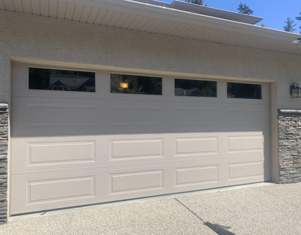 RC16 sandstone garage door with top panel glass by Legacy Garage Doors