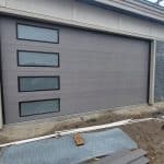 Mid-century modern weathered wood garage door with black frames by Legacy Garage Doors