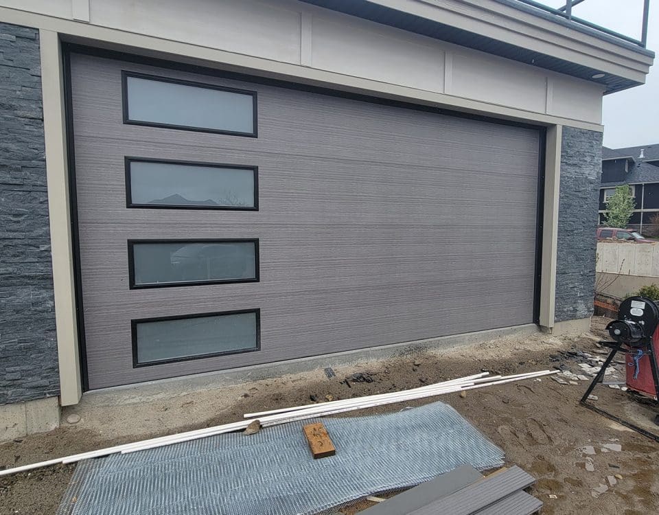 Mid-century modern weathered wood garage door with black frames by Legacy Garage Doors