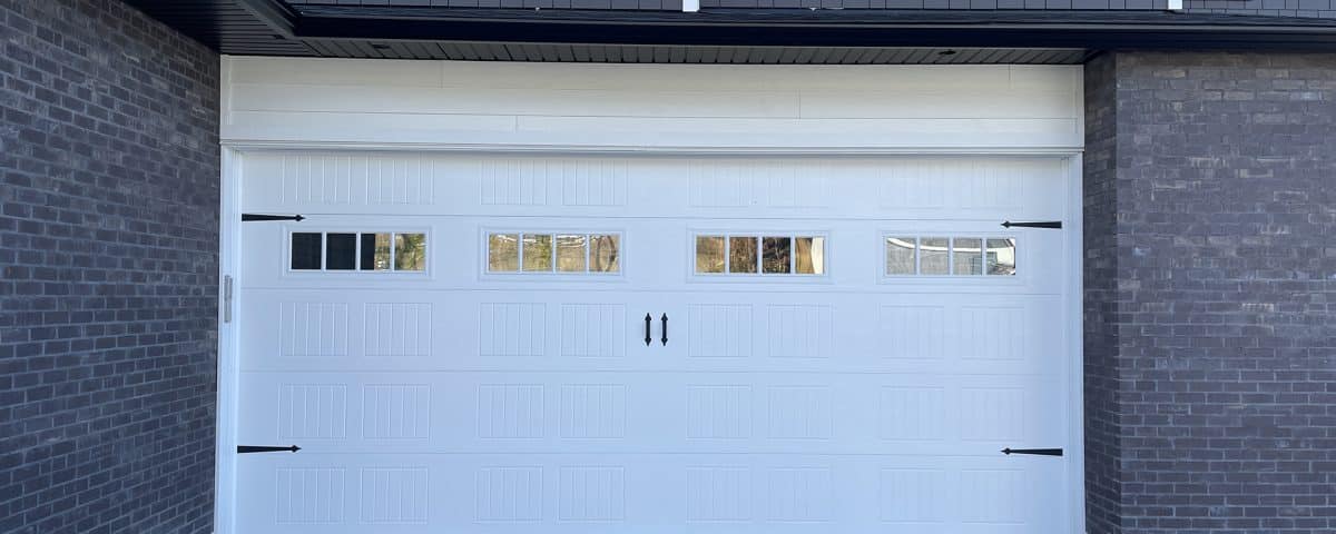 Carriage Craft garage door with decorative hardware and glass panels by Legacy Garage Doors