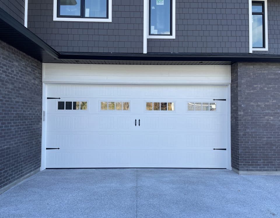 Carriage Craft garage door with decorative hardware and glass panels by Legacy Garage Doors