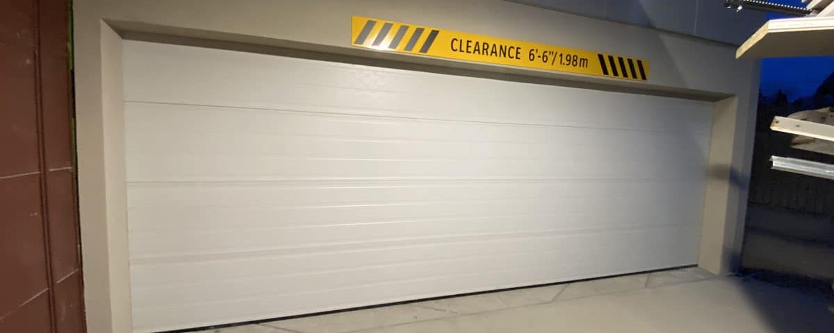 Custom steel garage door for a residential exterior, featuring a modern design