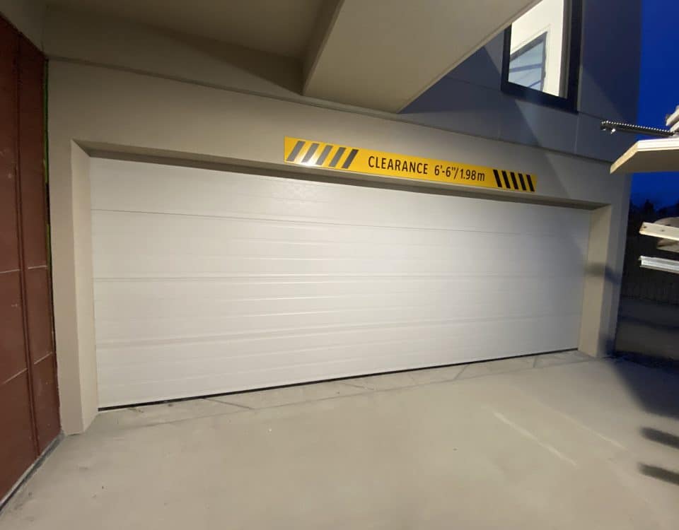 Custom steel garage door for a residential exterior, featuring a modern design