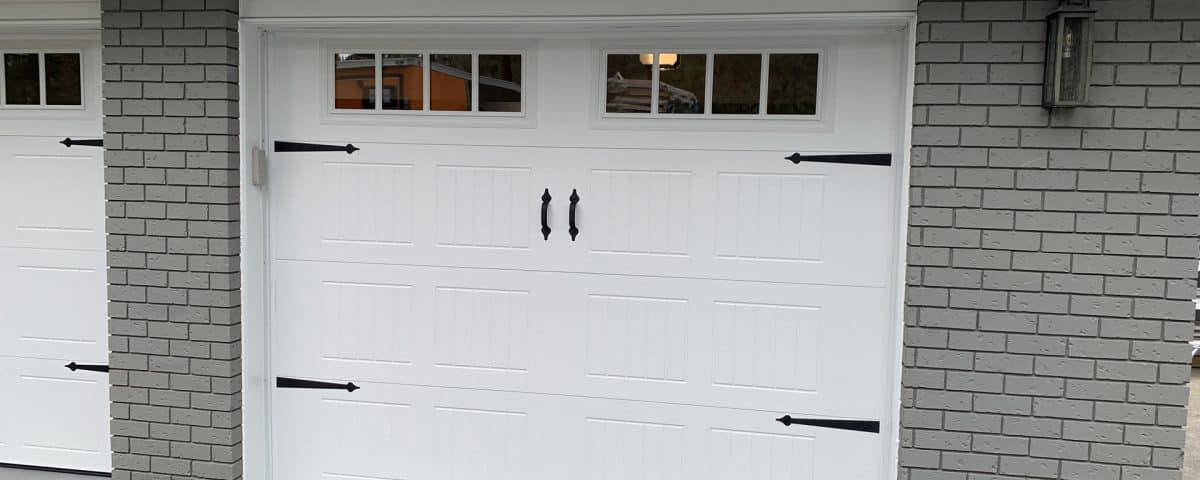 9x7-foot carriage-style garage door featuring glass panels and decorative hardware in a classic design for residential use