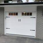 9x7-foot carriage-style garage door featuring glass panels and decorative hardware in a classic design for residential use