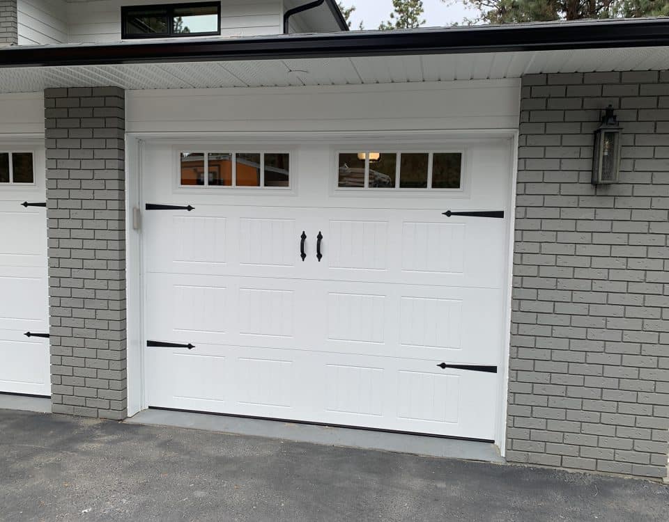 9x7-foot carriage-style garage door featuring glass panels and decorative hardware in a classic design for residential use