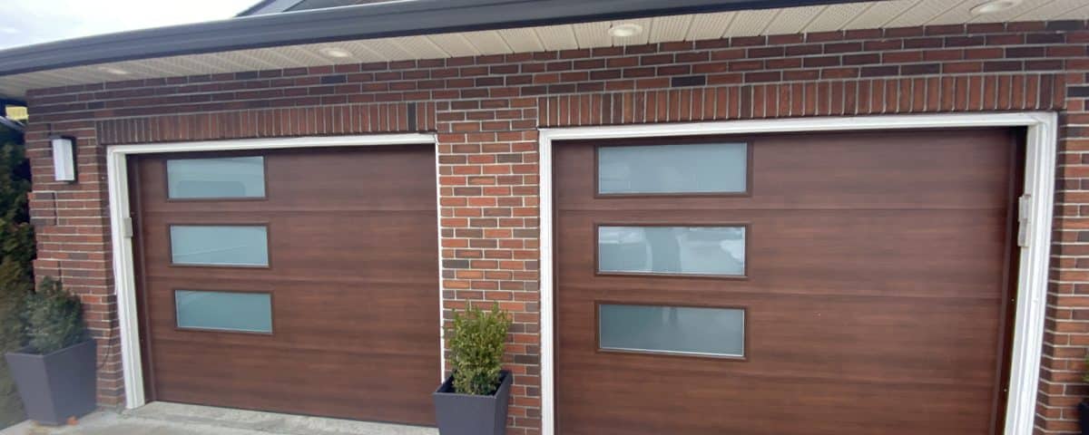 Elite flush walnut garage door with 38x14 satin glass windows by Legacy Garage Doors