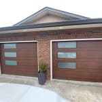Elite flush walnut garage door with 38x14 satin glass windows by Legacy Garage Doors