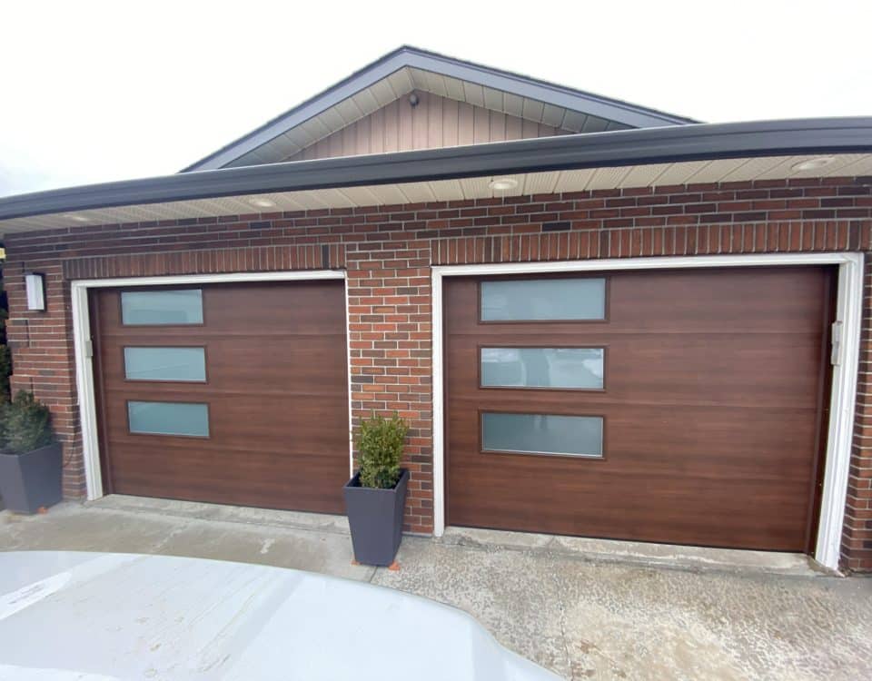 Elite flush walnut garage door with 38x14 satin glass windows by Legacy Garage Doors