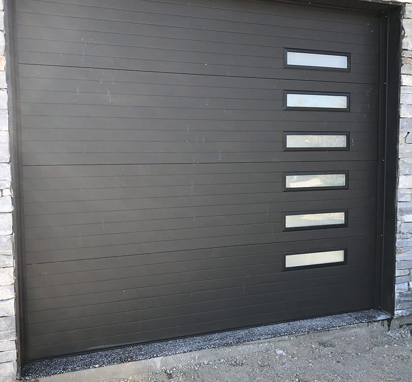 harcoal-colored contemporary garage door featuring stacked narrow glass panels and a sleek right-hand section design for modern homes