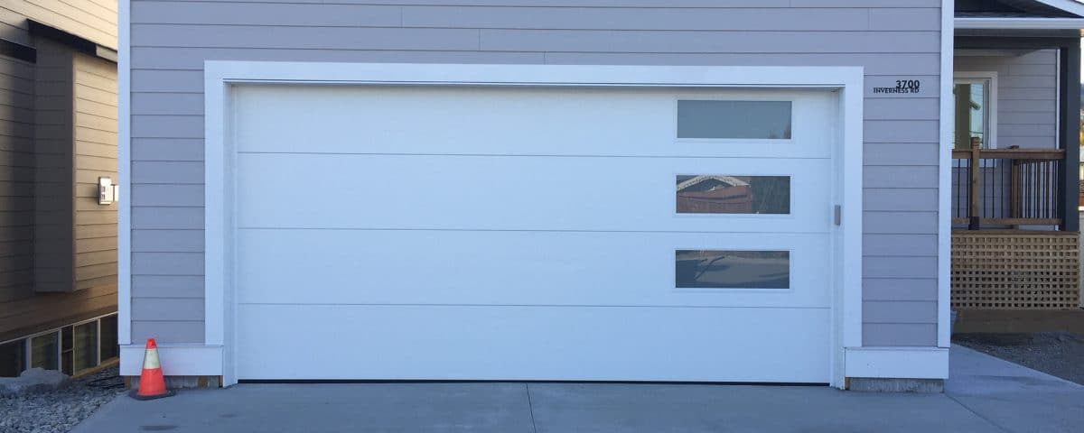 Flush white garage door with double-pane satin glass panels by Legacy Garage Doors