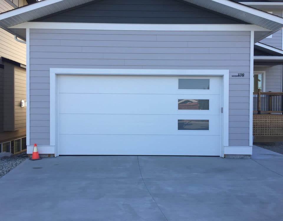 Flush white garage door with double-pane satin glass panels by Legacy Garage Doors