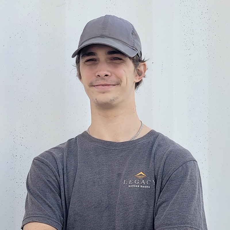 Headshot of Isaac with a professional appearance, featuring a friendly smile and gray company shirt